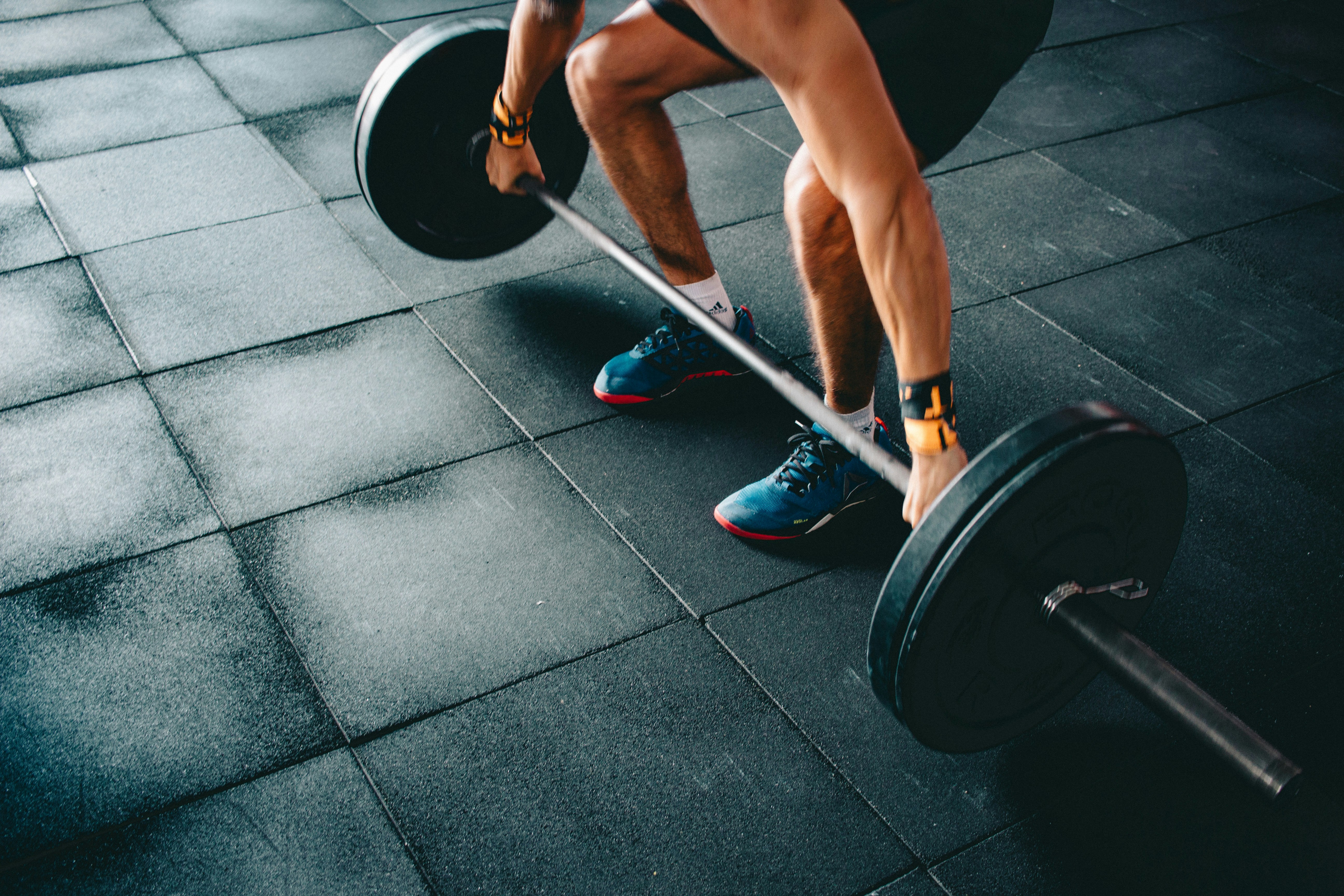 person holding black barbell